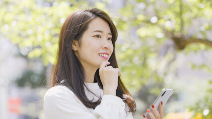 屋外でスマホを操作する女性