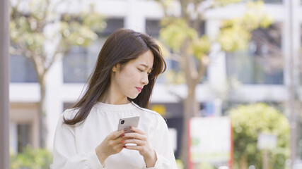 屋外でスマホを操作する女性