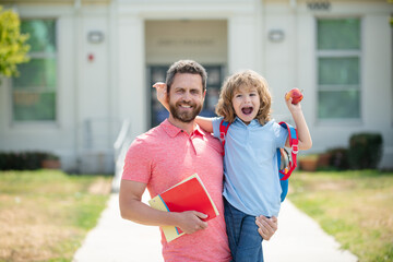 Portrait of teacher and happy pupil. Father supports and motivates son. Kid going to primary...