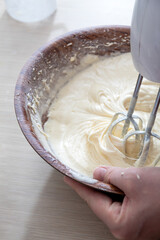 Mixing the dough in a bowl with a mixer. Close-up. Selective focus.
