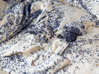 The texture of batter mixed with poppy seeds. Cooking food. Selective focus.