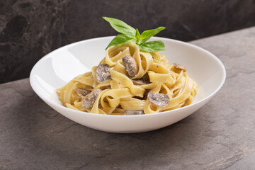 A view of a plate of Tagliatelle noodles with mushrooms in cream sauce on white plate.  Mediterranean cuisine. Isometric style.