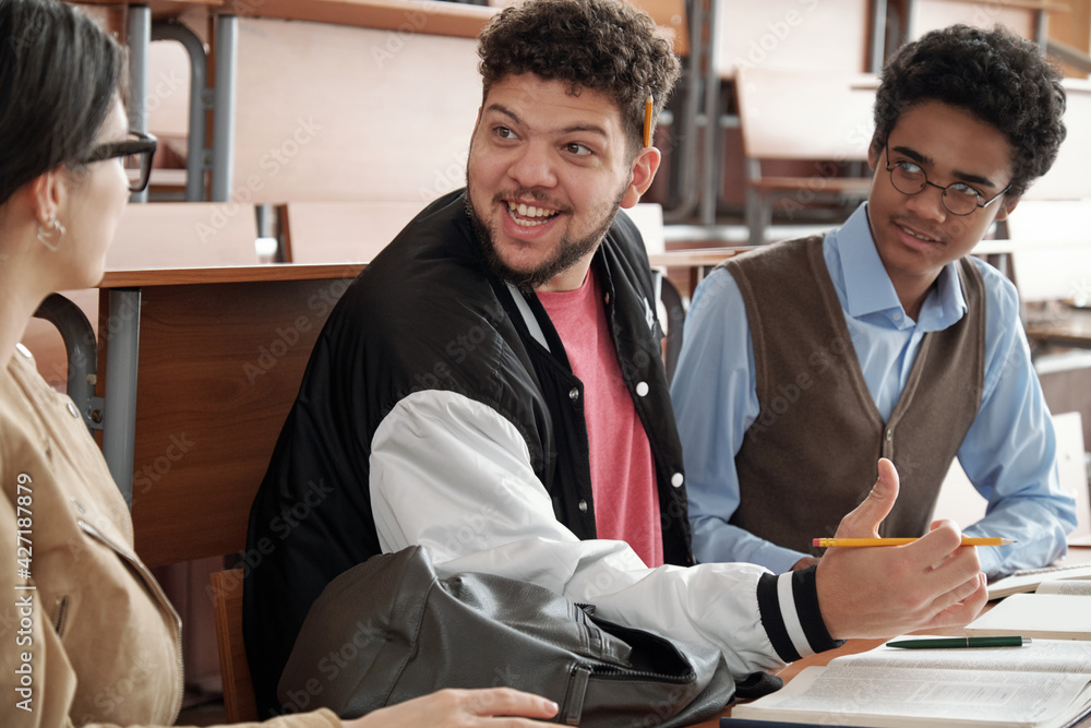 Aufkleber Happy guy with pencil looking at one of his groupmates during discussion of project topic or passage from book at lesson in lecture hall