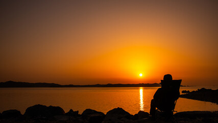 의자에 앉아 일몰을 감상하는 한 사람(A man sitting in a chair and watching the sunset