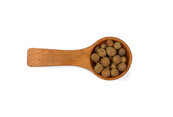 Allspice, pimento spice, Jamaican pepper pile in a wooden spoon isolated on white background