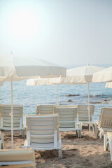 Failed tourist season, covid-19, epidemic concept. Empty beach with beach umbrellas, nobody on the beach. Beautiful blue sky, hot weather. Beach with no travellers and tourists. Vertical image.