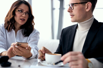 nice business lady or manager explain business idea to colleague, showing something on smartphone