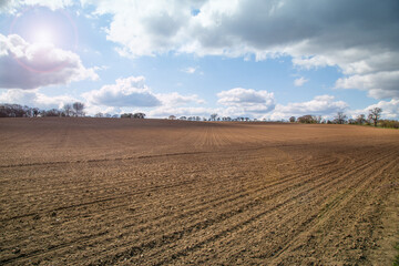 Fototapeta na wymiar Plowed agricultural spring field during sunny day,