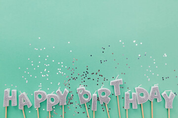 Silver glitter candles on pastel background.