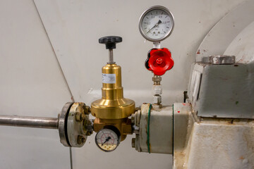 Manually adjustable oil pressure regulator with manometer on an industrial oil lubricated machine, the Netherlands
