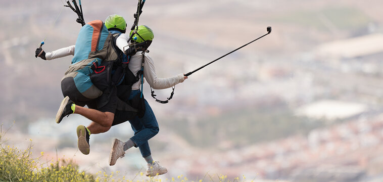Tandem paraglider running to do a forward launch, launching flight above