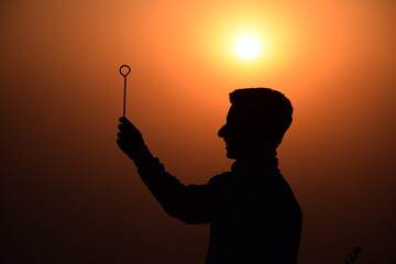 stick on boy hand and sunset background