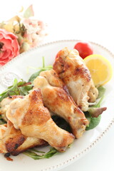 Homemade asian cuisine, barbecue grilled chicken drumsticks served with baby leaves and lemon