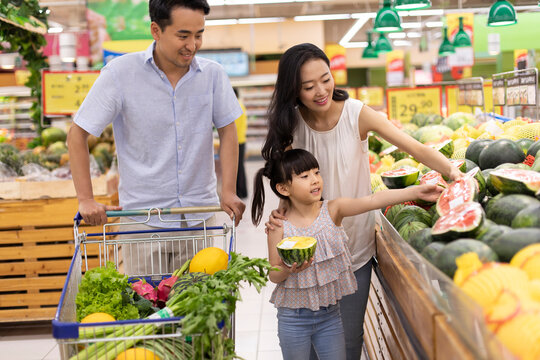 Happy young family shopping in supermarket