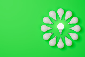 Circle composed of lighted bulbs on a green background. Concept of energy saving and renewable energies. 3d render. - 427196260