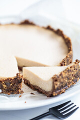 Vegan tofu cheesecake on white plate, close up. Healthy plant based dessert concept.