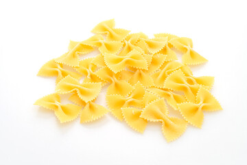 Dry uncooked farfalle pasta on white background