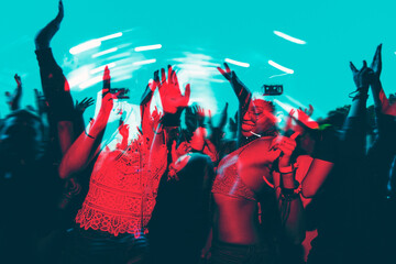 People dancing in a music festival in double color exposure effect