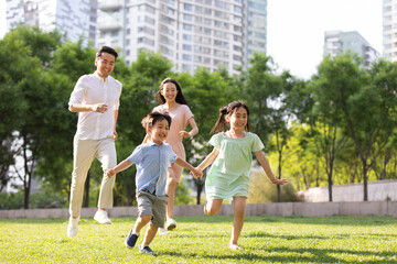 Happy young family playing in park