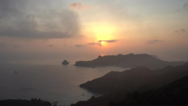 Magnificent Golden Hour Sunset With Misty Clouds Flying Low Above Tranquil Islands. wide shot
