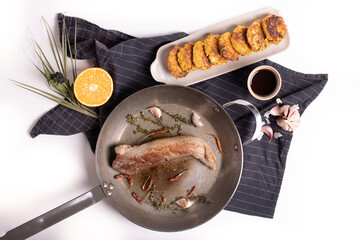 close up of tasty pork loin in a pan, on a white background