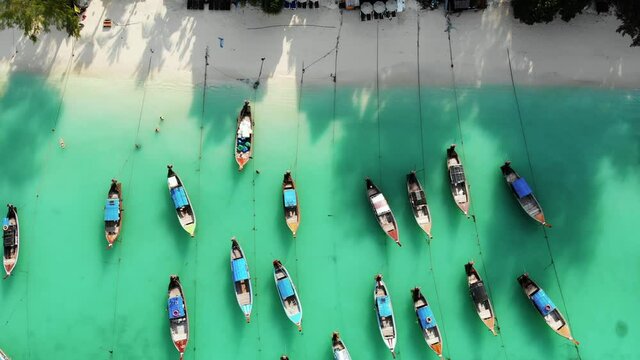 Overhead aerial view of traditional long tail boats on tropical sea in Thailand