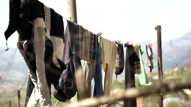Clean washed clothes hanged on wire, blurred nature background in village