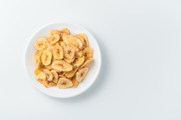 Dried banana chips on a white background.