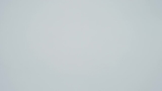 A modern eco-friendly, economical LED lamp rolls over a white surface and stops in front of the camera. Macro. Closeup