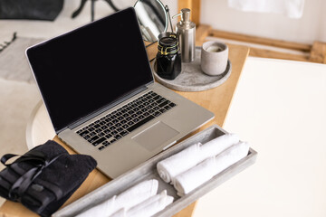 the laptop is on the table in the bathroom, table for the laptop.