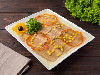 Tongue jelly on a white plate. Aspic for the holiday. Space for text. Rustic style. Copy space. Traditional Russian snack for the New Year.