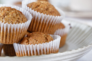Carrot cupcakes in a round plate with a fragrant coffee on a white wall