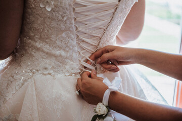 the bride wears a wedding dress, the godmother helps her