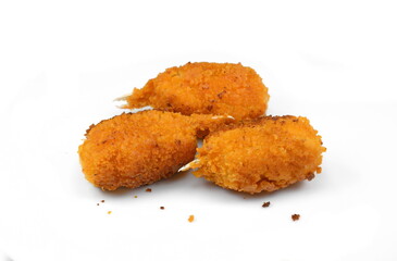 Three fried breaded surimi crab claws, in perspective, isolated on white.