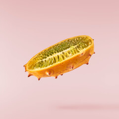 Fresh ripe kiwano falling in the air isolated