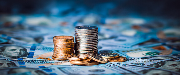 Stacks of coins against the background of hundred-dollar bills are scattered throughout the space.