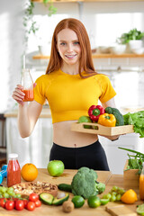 Friendly redhead female holding natural detox juice in hands