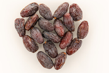 Date fruits on a white heart-shaped background top view