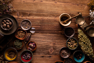 Natural medicine background. Preparation of herbs composition. Assorted dry herbs in bowls and...