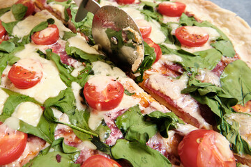 Pizza with cheese, tomatoes, spinach and smoked sausage