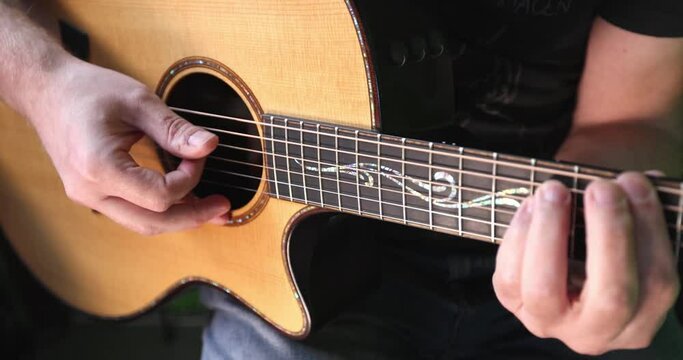Playing acoustic western guitar in slow motion