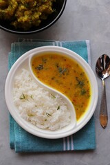 Healthy nutritious Indian comfort food Dal Chawal thali or Dal Rice, also commonly known as Varan bhat in Marathi. Served in two way ceramic plate. Over white background with copy space.