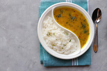Healthy nutritious Indian comfort food Dal Chawal thali or Dal Rice, also commonly known as Varan bhat in Marathi. Served in two way ceramic plate. Over white background with copy space. - obrazy, fototapety, plakaty