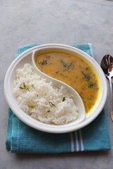 Healthy nutritious Indian comfort food Dal Chawal thali or Dal Rice, also commonly known as Varan bhat in Marathi. Served in two way ceramic plate. Over white background with copy space.