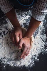 Close-up of hands kneading.
