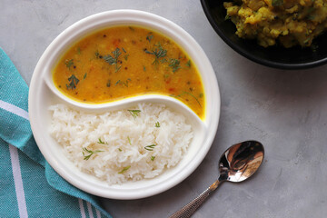 Healthy nutritious Indian comfort food Dal Chawal thali or Dal Rice, also commonly known as Varan bhat in Marathi. Served in two way ceramic plate. Over white background with copy space.