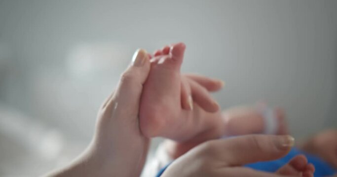 Close up of happy mother kissing feet of new born baby