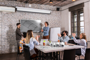 Group of young people discussing architectural designs in the creative office.