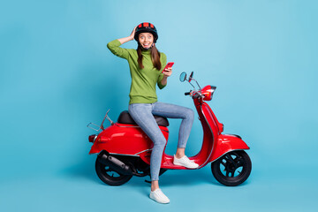 Fototapeta na wymiar Full length body size view of attractive amazed cheery girl riding moped using device isolated over bright blue color background