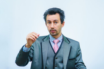 A man with tousled hair in a business suit straightens his hair